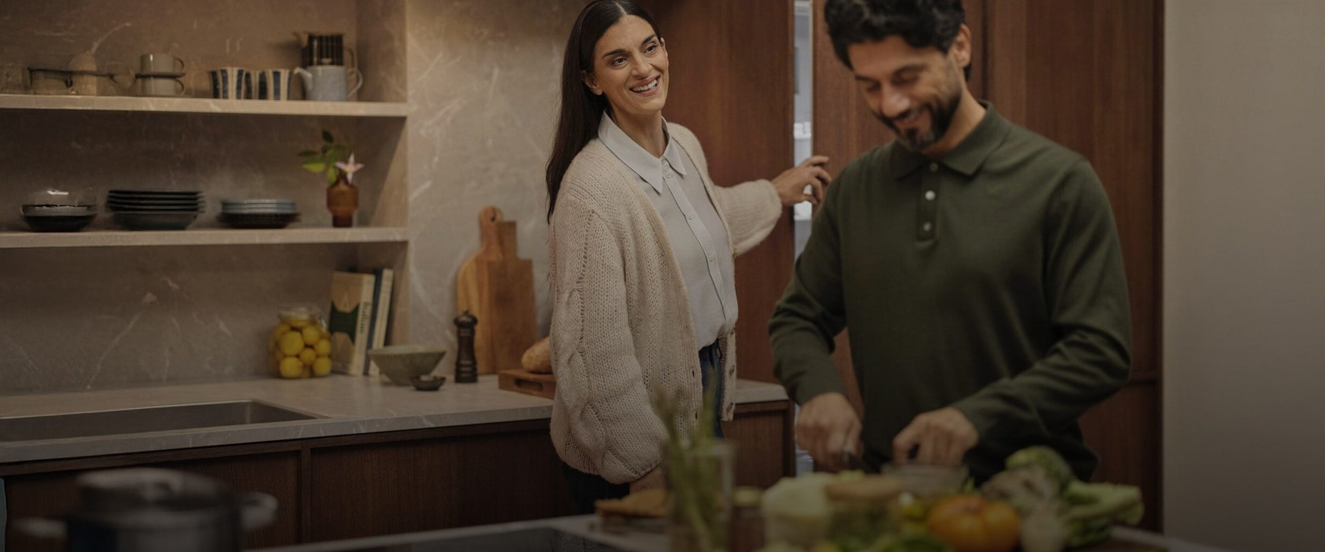 Et par som lager mat i et moderne kjøkken med integrerte kjøle- og fryseløsninger fra Electrolux